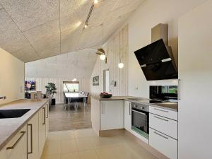 cocina con armarios blancos y comedor en 14 person holiday home in Faaborg, en Bøjden