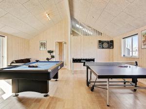 a room with two pool tables and a piano at 20 person holiday home in Hasselberg in Kappeln