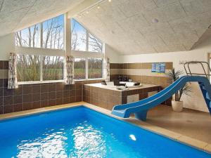 a bathroom with a swimming pool with a slide at 16 person holiday home in Hasselberg in Kappeln