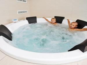 dos jóvenes sentados en un jacuzzi en 14 person holiday home in Faaborg, en Bøjden