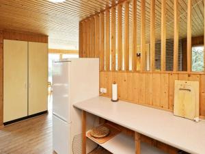 Saltumにある6 person holiday home in Saltumの白い冷蔵庫付きのキッチン、木製の壁