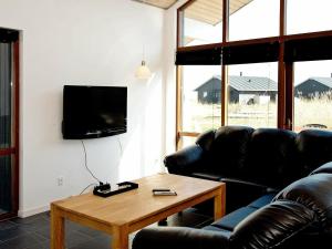 a living room with a couch and a table and a tv at 8 person holiday home in Ulfborg in Thorsminde