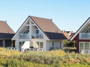 a white house with a brown roof at Two-Bedroom Holiday home in Wendtorf 34 in Wendtorf