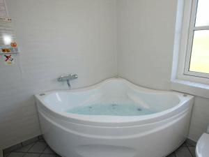 a white bath tub in a bathroom with a window at 8 person holiday home in Hanstholm in Vigsø