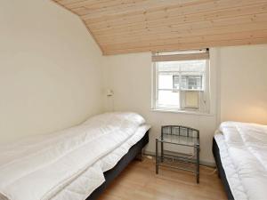 ホにあるTwo-Bedroom Holiday home in Blåvand 28の窓付きの小さな部屋のベッド2台