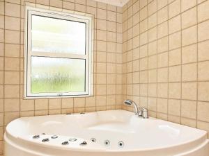 baño con bañera blanca y ventana en 10 person holiday home in Fjerritslev en Torup Strand