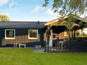 a house with a porch with a picnic table at Holiday home Juelsminde XV in Sønderby