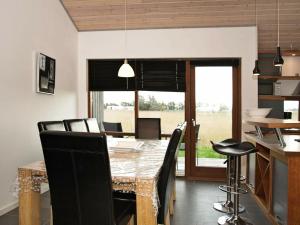 Thorsminde的住宿－8 person holiday home in Ulfborg，厨房以及带桌椅的用餐室。