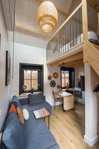 a living room with a blue couch and a loft at Luxury Chalets Monnickendam in Monnickendam