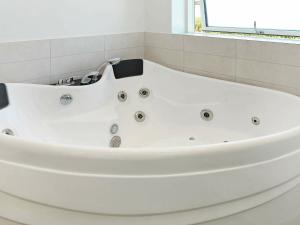 8 person holiday home in Faaborg في Bøjden: حوض استحمام أبيض في حمام مع نافذة