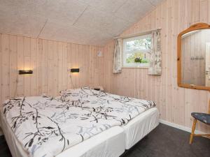 een slaapkamer met een groot bed in een kamer met een raam bij Holiday home Rømø XXVIII in Rømø Kirkeby