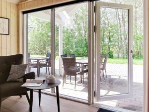 a screened in porch with a table and chairs at 16 person holiday home in Hasselberg in Kappeln