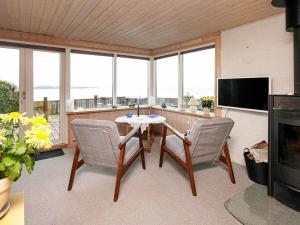 a living room with a table and chairs and a television at 4 person holiday home in Struer in Struer