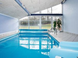 ein Pool mit blauem Wasser in einem Haus in der Unterkunft Four-Bedroom Holiday home in Hadsund 25 in Nørre Hurup