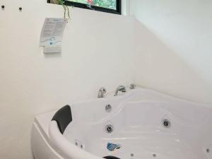 een wit bad in een badkamer met een bord aan de muur bij Three-Bedroom Holiday home in Knebel 28 in Skødshoved Strand