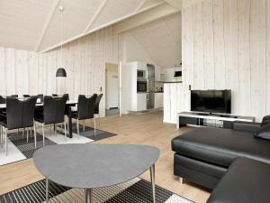 een woonkamer met een zwarte bank en een tafel bij Holiday home Blåvand IX in Blåvand