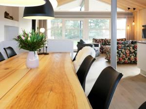 Nørre HurupにあるFour-Bedroom Holiday home in Hadsund 25のダイニングルーム(大きな木製テーブル、黒い椅子付)