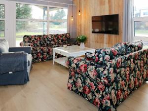 a living room with two couches and a tv at Four-Bedroom Holiday home in Hadsund 25 in Nørre Hurup
