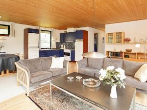 ein Wohnzimmer mit 2 Sofas und einem Tisch in der Unterkunft 4 person holiday home in V ggerl se in Bøtø By