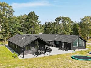 a house with a black roof and a pool at Eight-Bedroom Holiday home in Frederiksværk in Melby