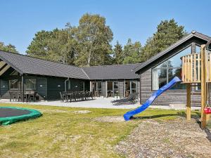 einen Spielplatz mit einer blauen Rutsche vor einem Haus in der Unterkunft Eight-Bedroom Holiday home in Frederiksværk in Melby
