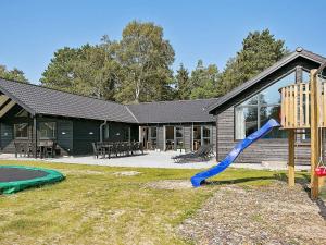 une aire de jeux avec un toboggan bleu en face d'une maison dans l'établissement Luxury Pool Villa Retreat - By Traum Ferienwohnungen, à Melby