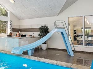 un tobogán azul en una casa con piscina en 19 person holiday home in Nex, en Bedegård