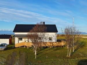 una casa con porche y un coche aparcado delante de ella en Holiday home Laukvik II, en Laukvik