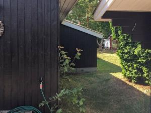 - une vue latérale sur une maison dotée d'une clôture noire dans l'établissement 5 person holiday home in Stege, à Stege