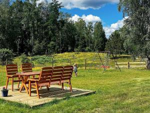 a wooden picnic table with two chairs and a playground at Five-Bedroom Holiday home in Hova 2 in Berga
