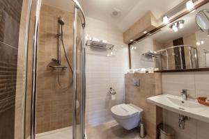 a bathroom with a shower and a toilet and a sink at Hotel Skarbek in Lubin