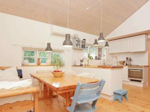 a kitchen and dining room with a wooden table at 8 person holiday home in J gerspris in Jægerspris