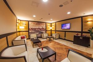 a living room with couches and a flat screen tv at Hotel Skarbek in Lubin