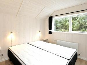 een groot bed in een kamer met een raam bij Holiday home Blåvand IX in Blåvand