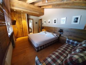 ein Schlafzimmer mit einem Bett und einem Sofa in einem Zimmer in der Unterkunft Hotel Boutique Puig Francó - Adults Only in Camprodon