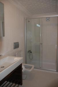 a bathroom with a shower and a toilet and a sink at Denizci Hotel in Sinop