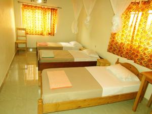 a room with three beds in a room at Rebero Kivu Resort in Kibuye