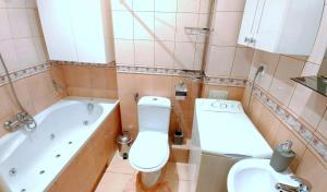 a bathroom with a toilet and a tub and a sink at Apartament TwojaNoc in Mielec
