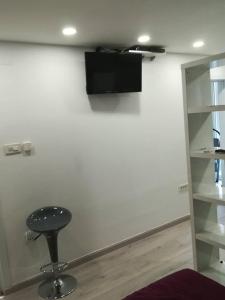 a stool in a room with a wall with a television at DRENO Apartman in Zagreb