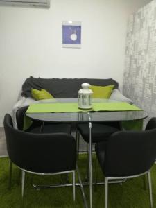 a table and chairs in a room with a couch at DRENO Apartman in Zagreb