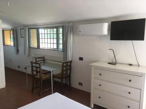a living room with a table and chairs and a tv at Villetta Gabriella in Impruneta