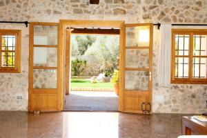 an open wooden door with a view of a yard at Agroturismo Son Burgues in Petra