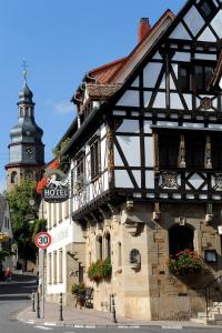 ein altes Gebäude mit einem Uhrturm auf einer Straße in der Unterkunft Weinkastell Zum Weissen Ross in Kallstadt