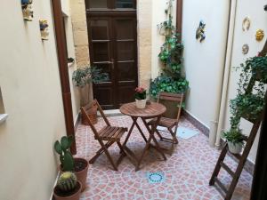 - une table et des chaises sur une terrasse couverte ornée de plantes dans l'établissement Casa Bidduzza, à Syracuse