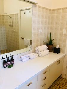 a bathroom with a sink with towels and a mirror at The Lake House Retreat in Keith