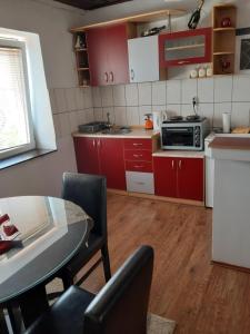 eine Küche mit roten Schränken und einem Tisch mit Stühlen in der Unterkunft Apartment NIKOLA ORANGE in Ohrid