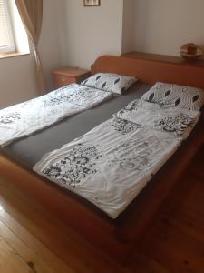 Una cama con una sábana blanca y almohadas. en Apartment NIKOLA ORANGE, en Ohrid