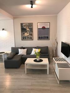 a living room with a couch and a coffee table at Apartament Ustecka Ostoja Na Wydmie in Ustka