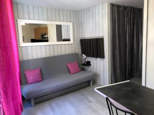un soggiorno con divano, tavolo e specchio di Résidence Bellevue a Cauterets