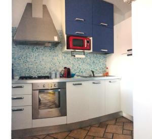 a kitchen with white cabinets and a red microwave at Incanto Apartment Golfo Aranci in Golfo Aranci